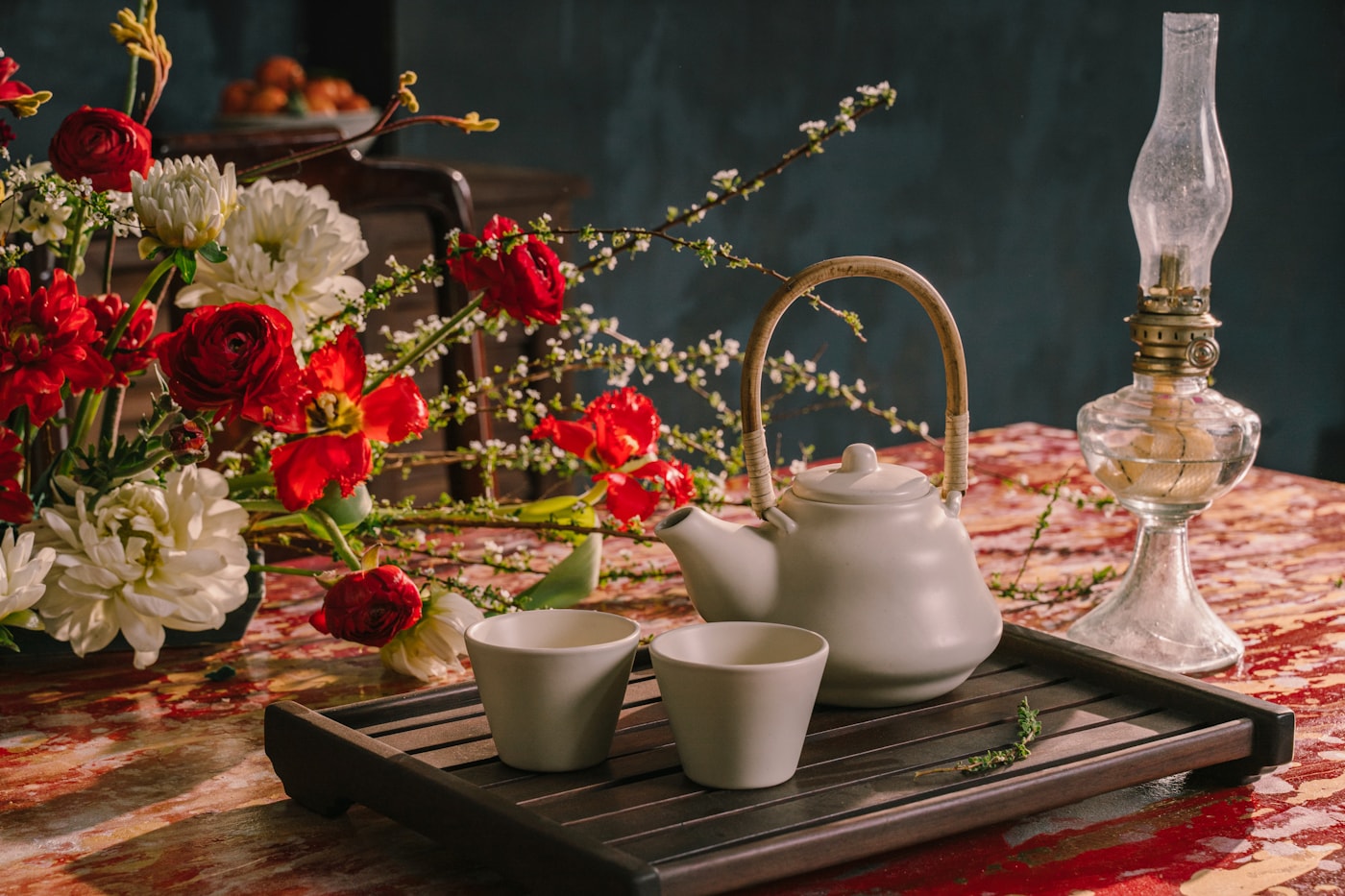 Nghi thức trà thảo mộc với ấm sứ và hoa tươi